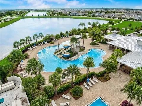 5415 Limelight Dr, Apollo Beach, FL 33572 - community pool with a water slide, a water view, and a patio