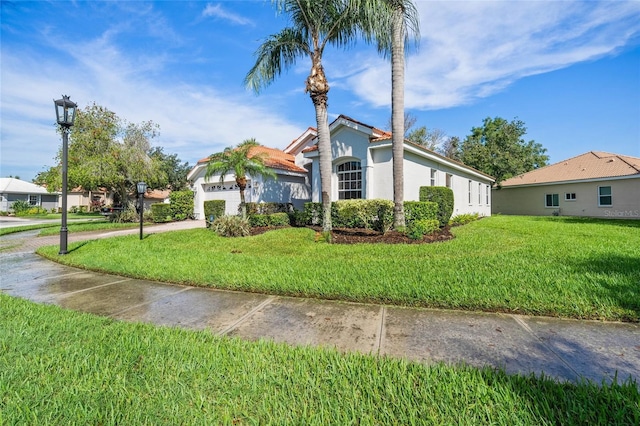 view of front of home with a garage and a front lawn