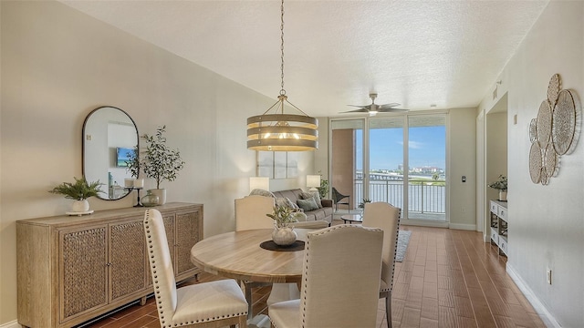 dining area featuring ceiling fan with notable chandelier, a textured ceiling, and floor to ceiling windows