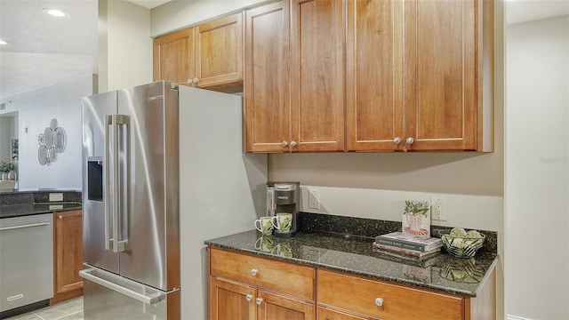 kitchen with dark stone countertops, light tile patterned floors, and appliances with stainless steel finishes