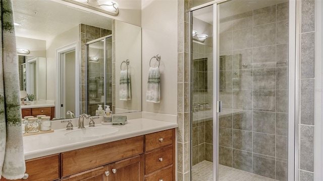 bathroom with a shower with door and vanity