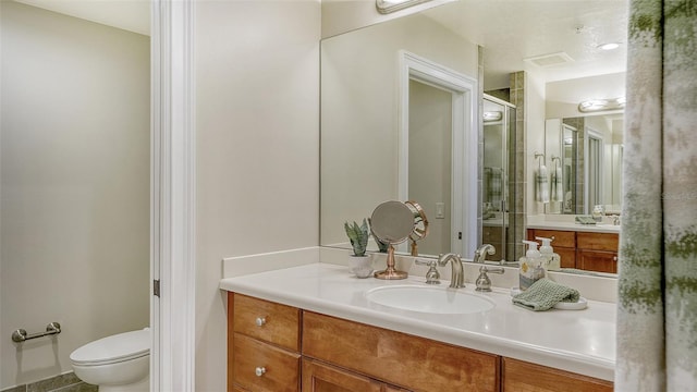 bathroom with an enclosed shower, vanity, and toilet