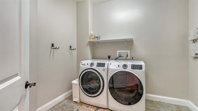 laundry area featuring light tile patterned floors and washing machine and clothes dryer