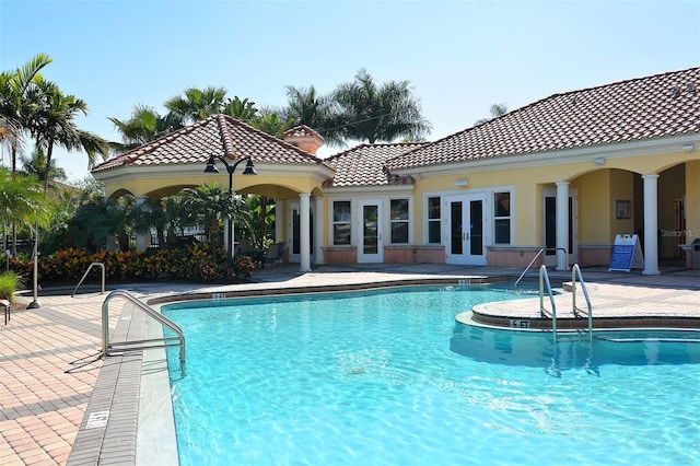 view of swimming pool with french doors and a patio