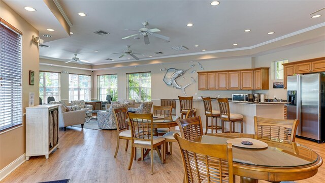 dining room with ceiling fan, crown molding, and light hardwood / wood-style flooring