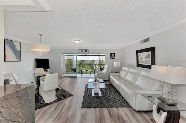 living room with a textured ceiling, light wood-type flooring, and crown molding