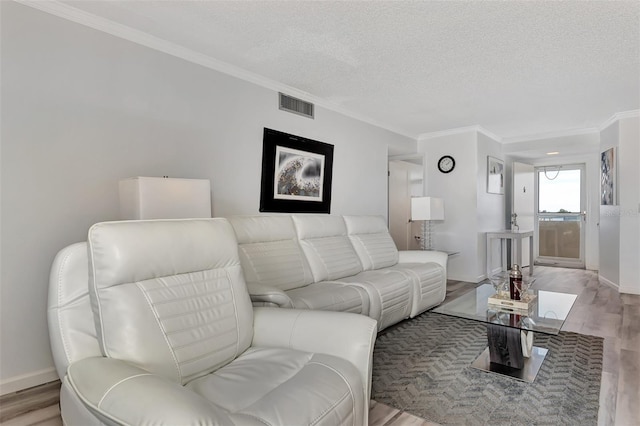 living room with a textured ceiling, light wood-type flooring, and ornamental molding