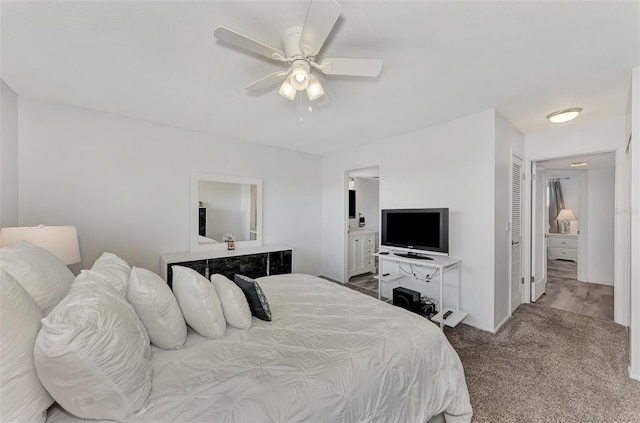 carpeted bedroom featuring ensuite bathroom, ceiling fan, and a closet