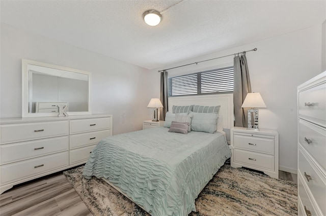 bedroom featuring a textured ceiling and light hardwood / wood-style floors