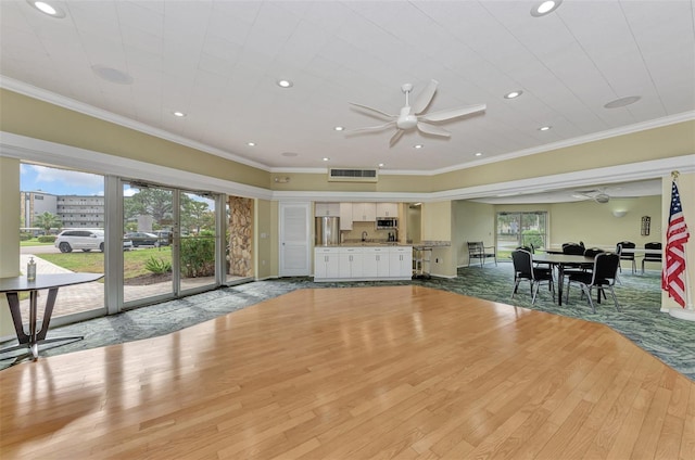 unfurnished living room featuring ceiling fan, light hardwood / wood-style floors, and crown molding