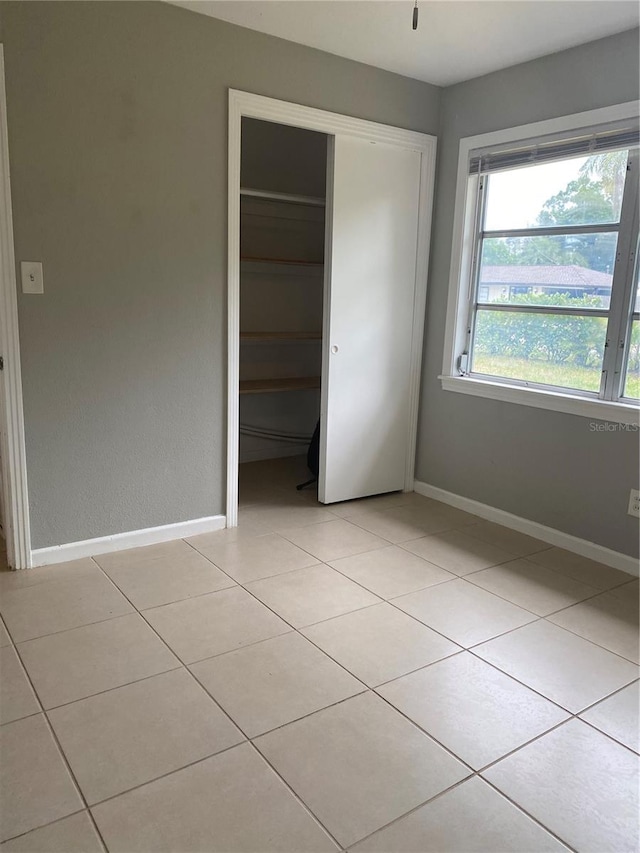 unfurnished bedroom featuring a closet and light tile patterned floors