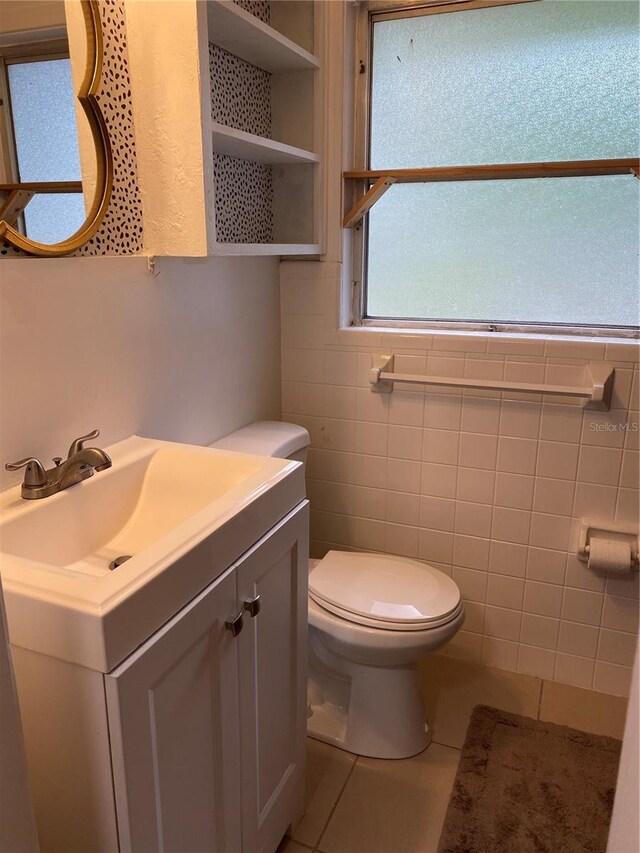 bathroom with tile walls, tile patterned flooring, vanity, and toilet