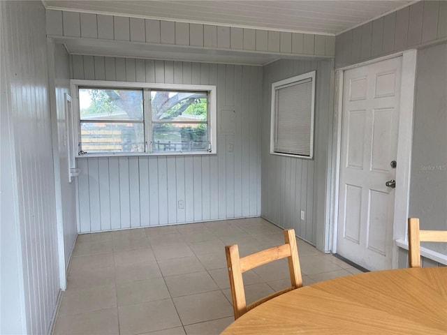 interior space with wood walls and light tile patterned floors