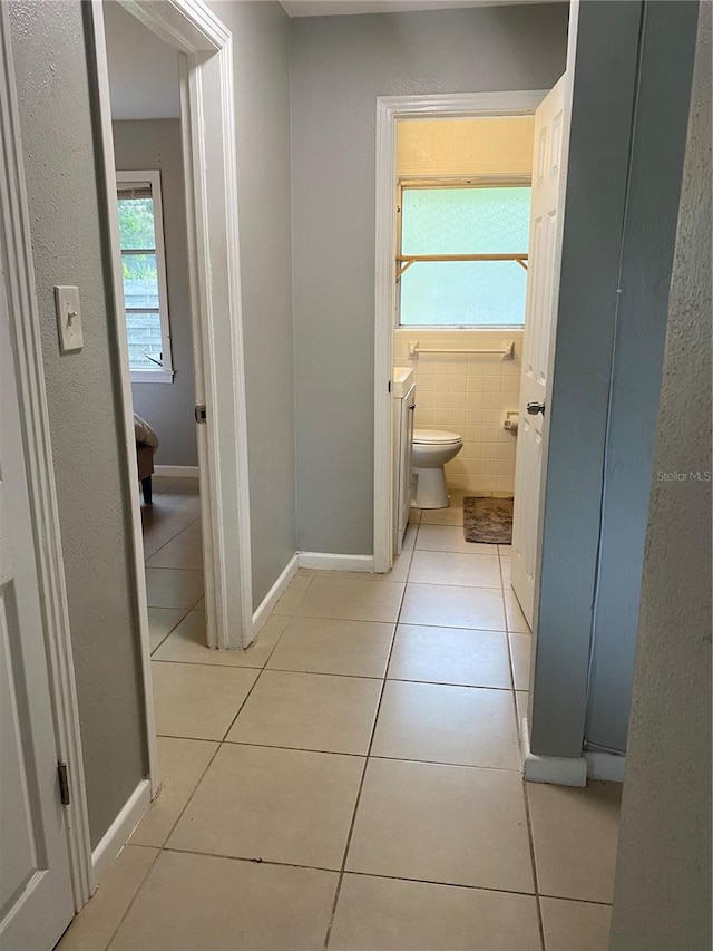 bathroom featuring toilet, tile patterned flooring, tile walls, and vanity