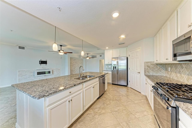 kitchen with white cabinetry, an island with sink, appliances with stainless steel finishes, backsplash, and sink