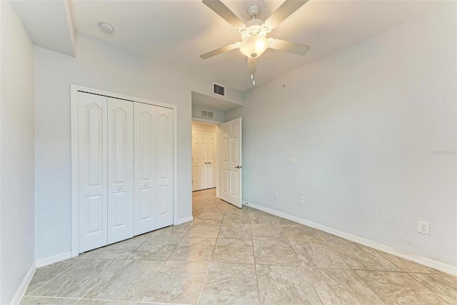 unfurnished bedroom featuring ceiling fan and a closet