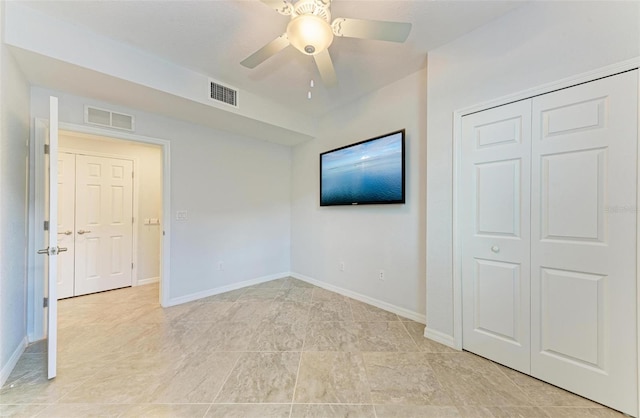 unfurnished bedroom featuring ceiling fan and a closet