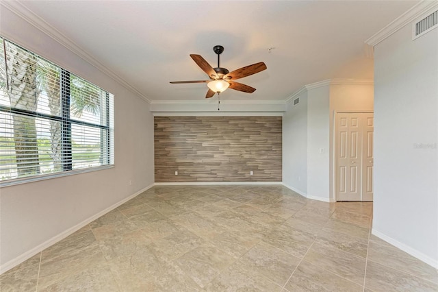 spare room featuring ceiling fan, crown molding, and wood walls