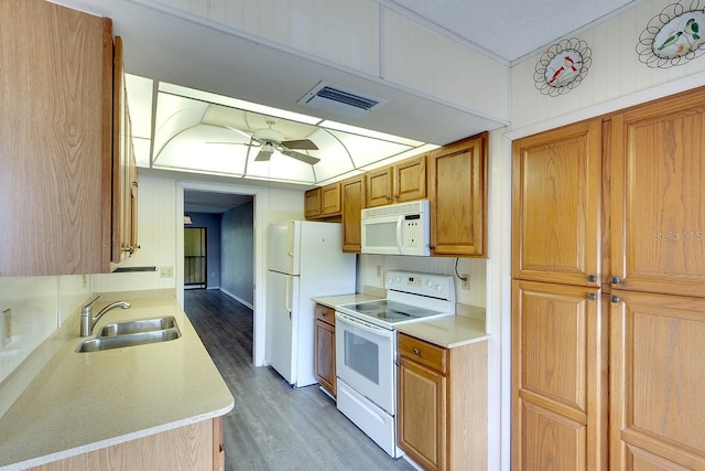 kitchen with white appliances, hardwood / wood-style flooring, sink, and ceiling fan