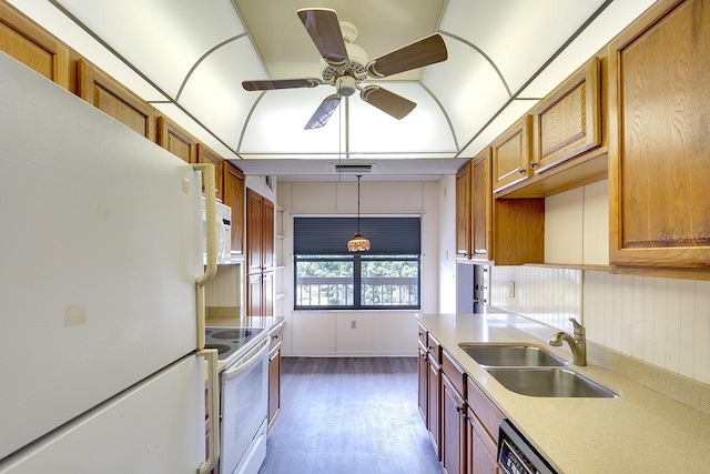 kitchen featuring hanging light fixtures, ceiling fan, hardwood / wood-style flooring, sink, and white appliances