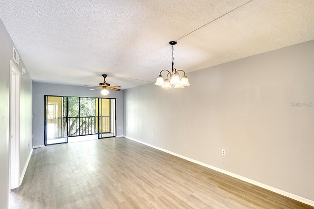 unfurnished room featuring a textured ceiling, ceiling fan with notable chandelier, and hardwood / wood-style floors