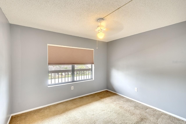 carpeted empty room featuring a textured ceiling and ceiling fan