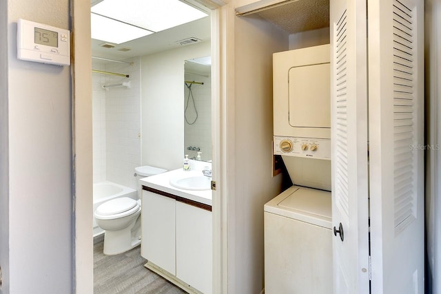 washroom featuring sink and stacked washer and dryer