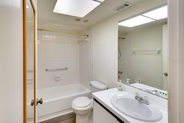 full bathroom featuring tiled shower / bath, hardwood / wood-style flooring, toilet, and vanity