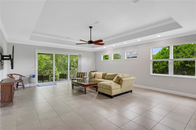 tiled living room with crown molding, ceiling fan, and a raised ceiling