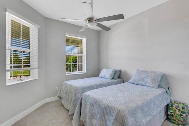 carpeted bedroom with multiple windows and ceiling fan