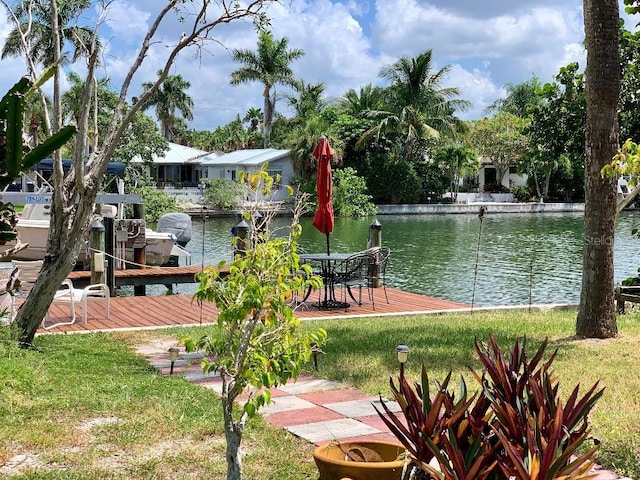 dock area with a yard and a water view