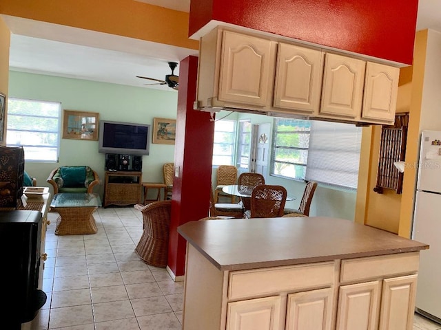 kitchen with cream cabinets, white fridge, light tile patterned floors, and ceiling fan