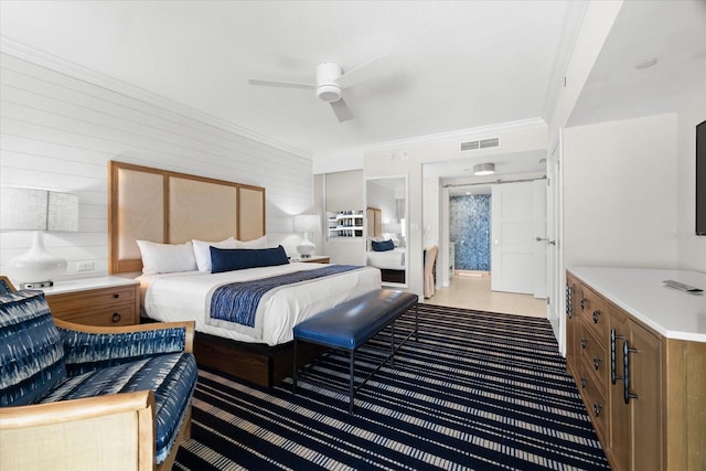 bedroom featuring ceiling fan, crown molding, and wooden walls