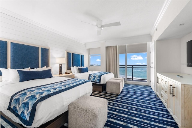 bedroom featuring access to outside, a water view, dark carpet, and ceiling fan