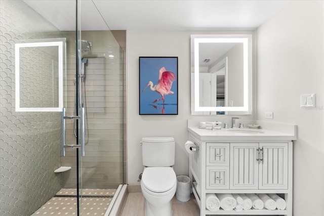 bathroom featuring tile patterned flooring, vanity, toilet, and an enclosed shower