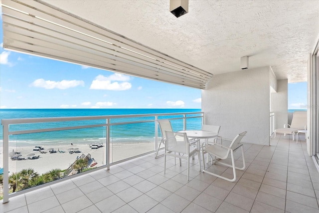 balcony featuring a water view and a beach view