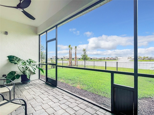 unfurnished sunroom featuring ceiling fan