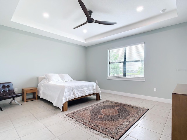 bedroom featuring a raised ceiling, ceiling fan, and light tile patterned flooring