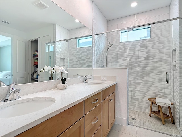 bathroom featuring tile patterned flooring, vanity, and an enclosed shower