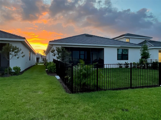 back house at dusk with a yard