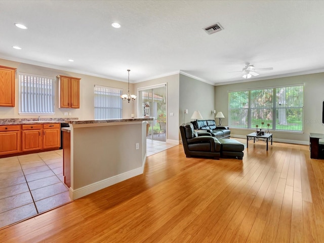 kitchen featuring decorative light fixtures, light wood-type flooring, ornamental molding, ceiling fan with notable chandelier, and sink