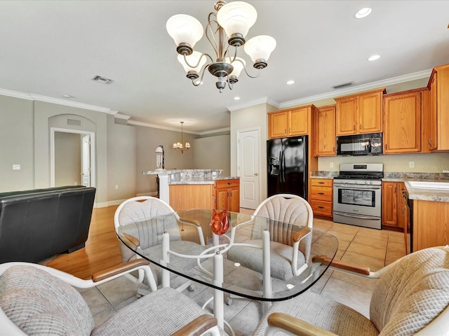 tiled dining space featuring a chandelier, ornamental molding, and sink