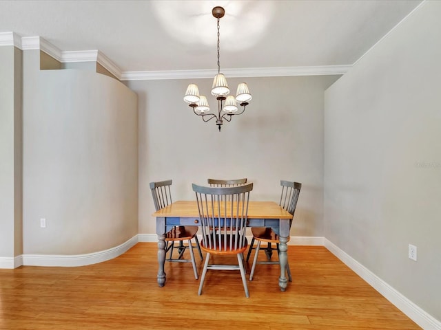 dining area featuring light hardwood / wood-style flooring, ornamental molding, and a chandelier