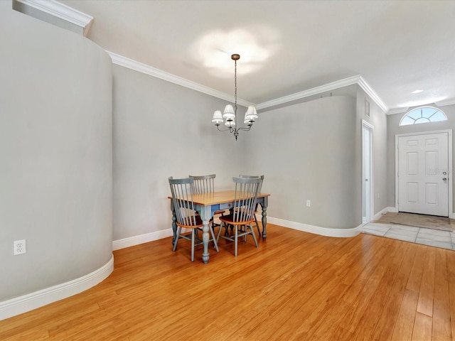 dining room featuring a chandelier, light wood-type flooring, and ornamental molding