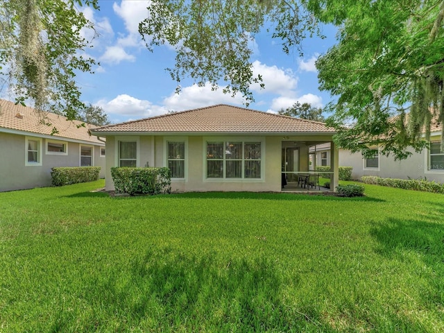 rear view of house featuring a lawn