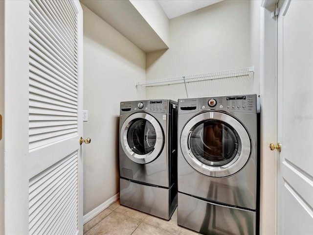 clothes washing area with light tile patterned floors and independent washer and dryer