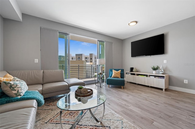 living area featuring baseboards and light wood-style floors