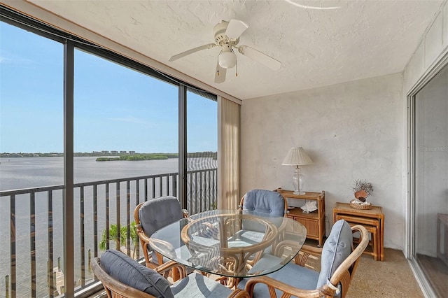 sunroom featuring a wealth of natural light, a water view, and ceiling fan