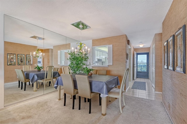 carpeted dining room with an inviting chandelier