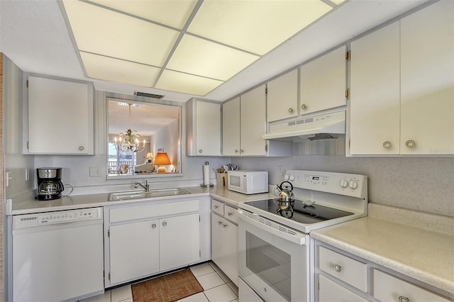 kitchen featuring white cabinetry, white appliances, an inviting chandelier, and sink